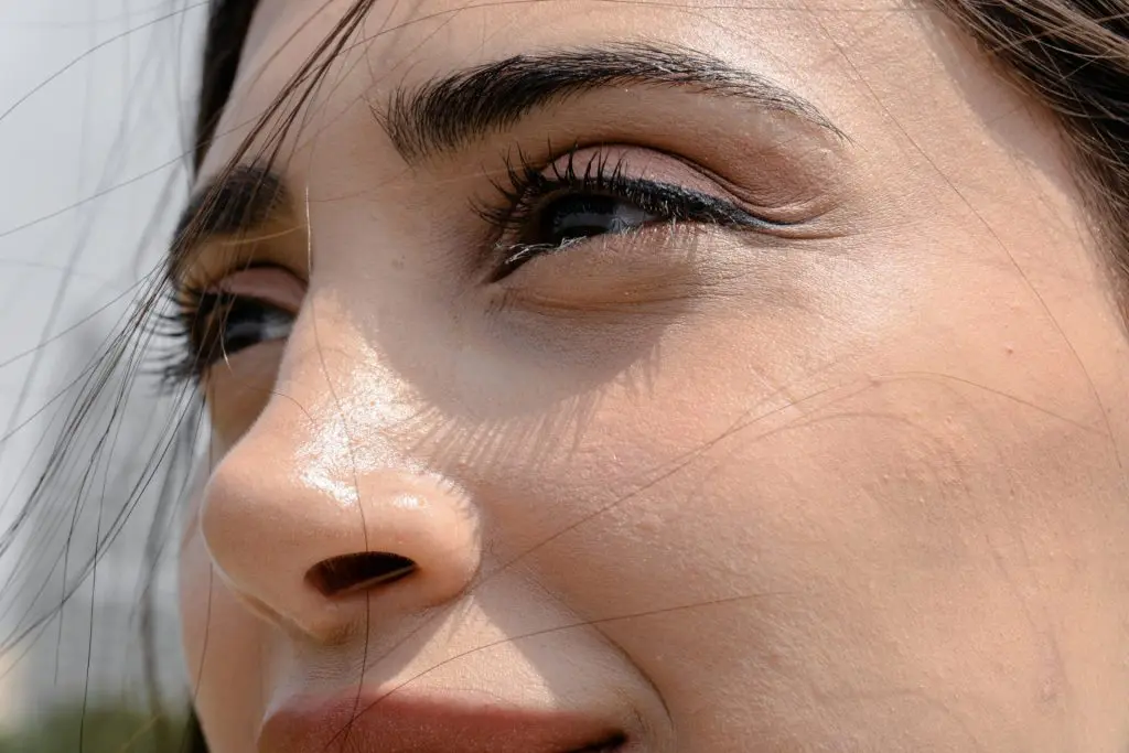 A close up of a woman smiling after her EMFace treatment.