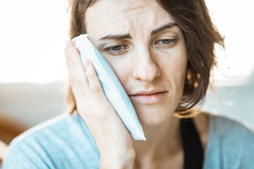 woman holding ice pack to jaw